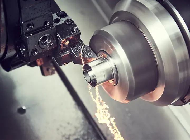 Drehmeißel zerspant ein rotierendes Metallteil, Späne fliegen