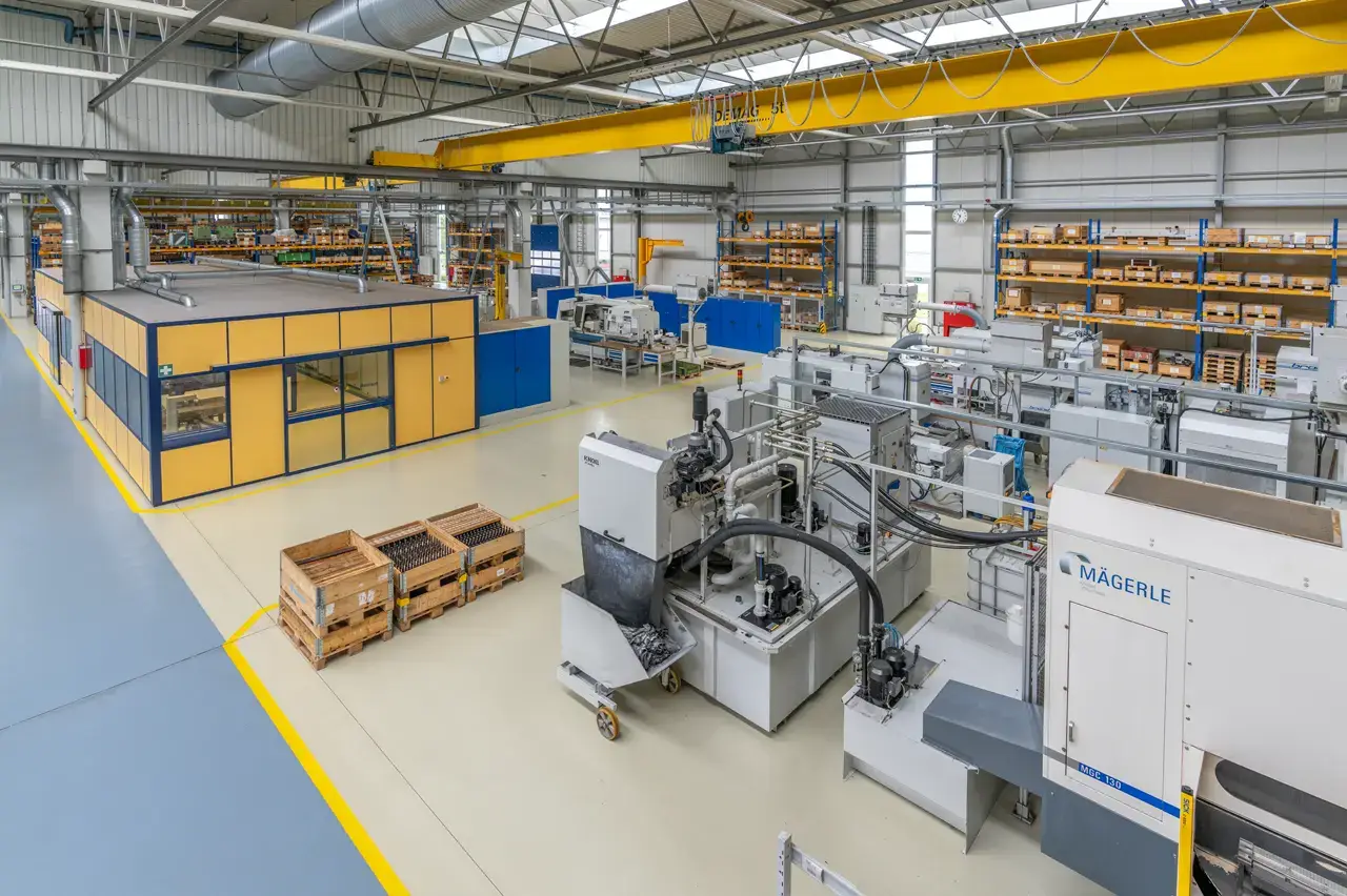 Blick in die Fertigungshalle mit CNC-Maschinen und Hallenkran